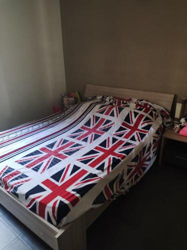 厄唐萨雷Appartement 2 chambres étang sale的床上有一床带英国国旗的被子