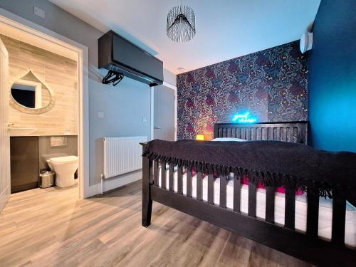 诺里奇Boutique Annexe Close To Central Norwich & Airport的一间卧室配有一张黑色婴儿床和蓝色的墙壁