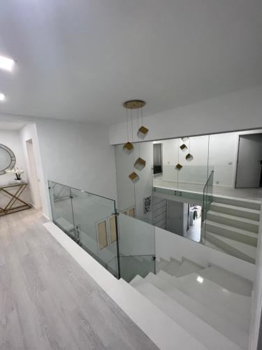 丰沙尔Apartamento Belo Horizonte的白色的房间,设有楼梯和玻璃栏杆