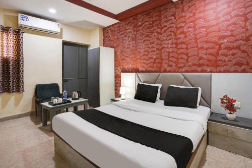 艾哈迈达巴德水晶酒店的一间卧室设有一张大床和红色的墙壁