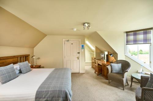 HalkirkUlbster Arms Hotel near Thurso的一间卧室配有一张床、一张书桌和一个窗户。