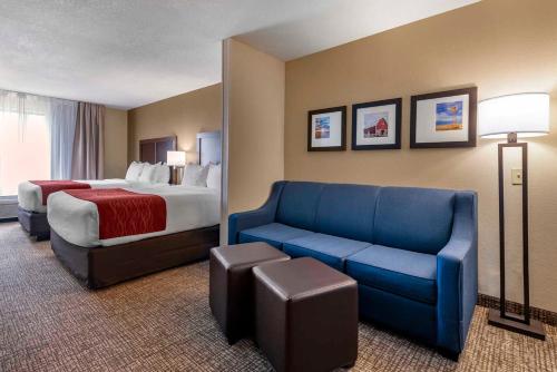 GoodlandComfort Inn & Suites的酒店客房,配有床和蓝色的沙发