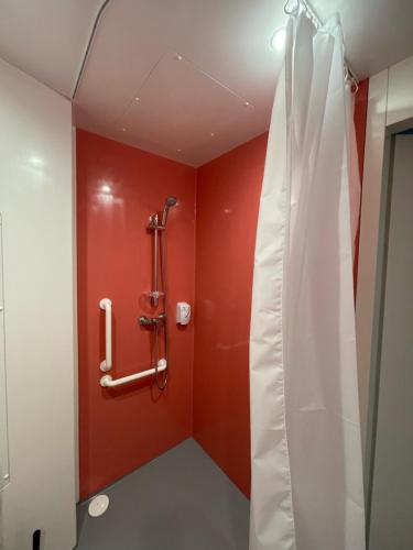 勒阿弗尔Smart Appart Le Havre 97的带淋浴的浴室,浴室设有红色的墙壁