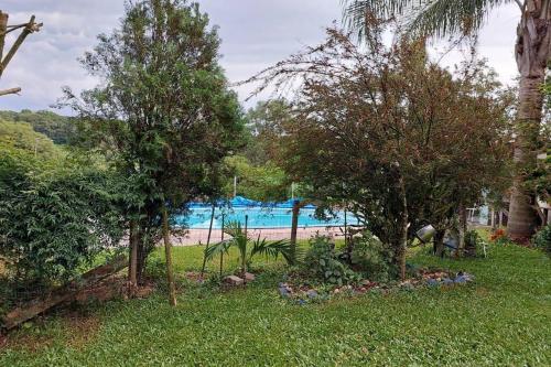 南卡希亚斯Recanto do Descanso的一座种植了树木的花园和一个游泳池