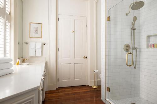 查尔斯顿The Jasmine House的带淋浴和盥洗盆的白色浴室