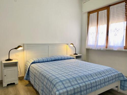 圣温琴佐Appartamento Elisa的一间卧室配有一张带蓝色铺面毯子的床