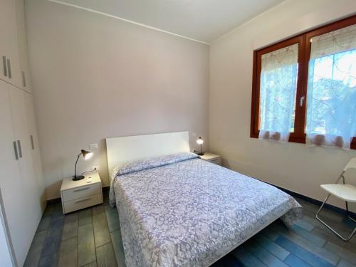 圣温琴佐Appartamento Giulia的白色的卧室设有床和窗户