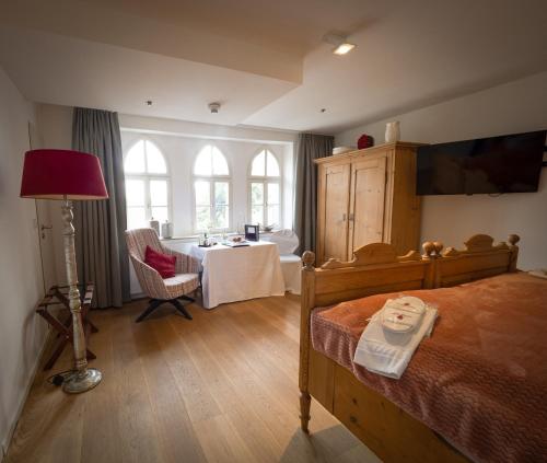 阿本贝格阿本贝格酒店的卧室配有床、桌子和窗户。