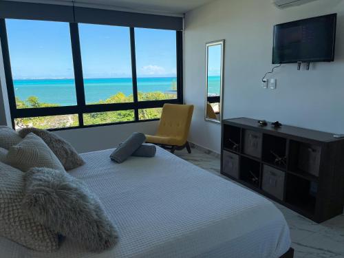 坎昆2BR Oceanfront Luxury Apartment in the Hotel Zone的一间卧室设有一张床和一个海景大窗户