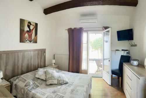 圣马迪拉莫les deux pins的一间卧室设有一张床和一个滑动玻璃门