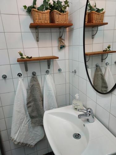 科尔莫登Marmorcafets B&B的浴室配有盥洗盆、镜子和毛巾