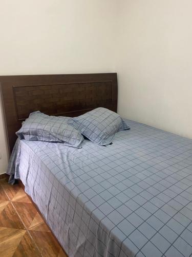 圣保罗Edículas da vivi的一间卧室配有一张带蓝色棉被和枕头的床