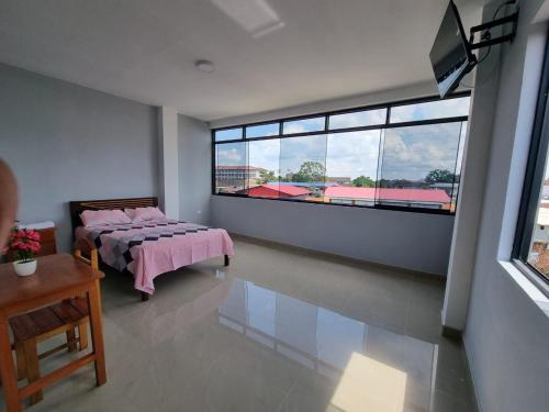 伊基托斯Casa Alojamiento Picuro Lodgind的一间卧室设有一张床和一个大窗户