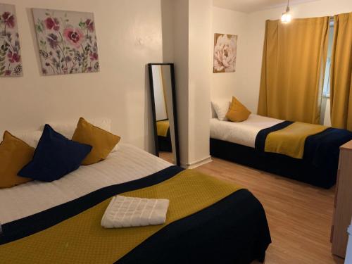 伦敦London Stratford 4 Bedrooms Apartment的带两张床和镜子的客房