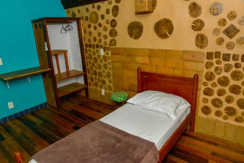 格拉瓦塔尔绿色生活环保旅馆的石墙客房的卧室配有床