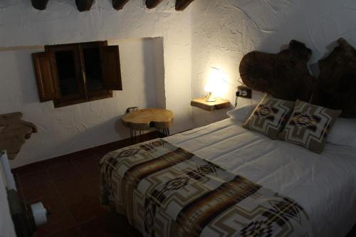 Cortijo Wenceslao II的一间卧室配有一张床和一张桌子上的台灯