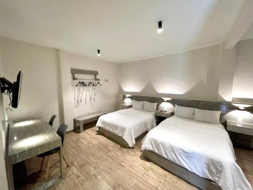 Chilpancingo Capital Suites的一间卧室配有两张床和椅子