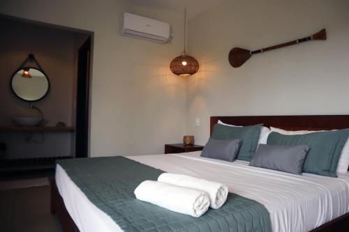 阿廷斯Pousada Vila Camurim的一间卧室配有一张大床和毛巾