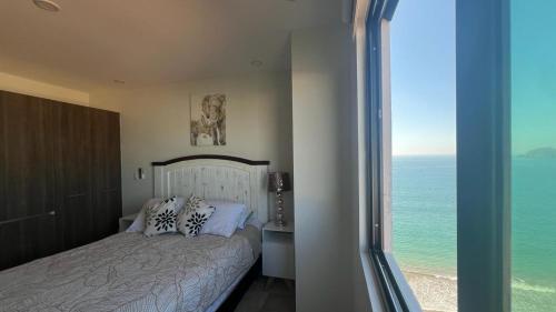 马萨特兰Mar Laguna Hotel的一间卧室配有一张床,享有海景