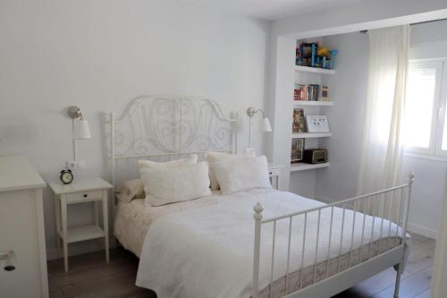 格拉纳达La morada del viajero的白色的卧室设有白色的床和窗户。