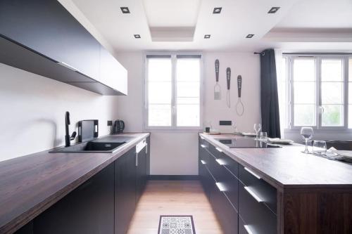 阿蒂斯蒙斯Le Black & White - 10 min Orly, 3 min gare Juvisy的厨房配有木制台面和一些窗户