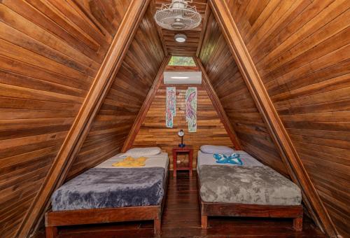 格兰德海滩Playa Grande Surf Camp的小木屋内一间卧室,配有两张床