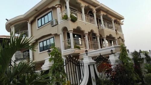 GoderichMAYRAH Inn - Your comfortable home from home in Freetown Sierra Leone的一座带阳台的大型建筑,种有植物