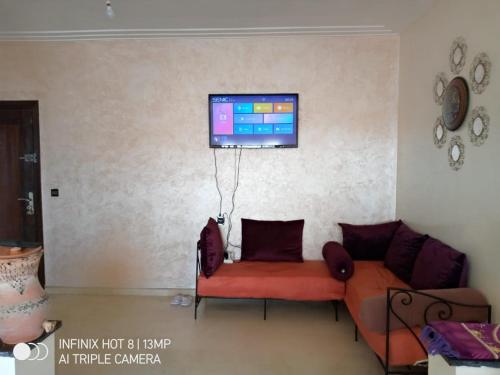杰迪代Propre appartement et bien équipé的客厅配有沙发和墙上的电视