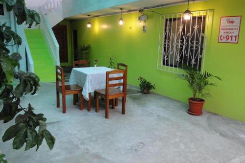 巴克里索莫雷诺港Casa de Huespedes Milena的绿墙客房内的桌椅