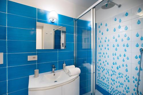 波西塔诺YourHome - H2O Marina Apt Sea View的蓝色的浴室设有水槽和镜子