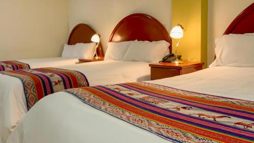 安达韦拉斯La Mansion Casa Hotel的酒店客房设有两张床和两盏灯。
