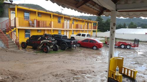 Hotel y Cabañas Cascada de Basaseachi的停在大楼前的一群汽车和卡车