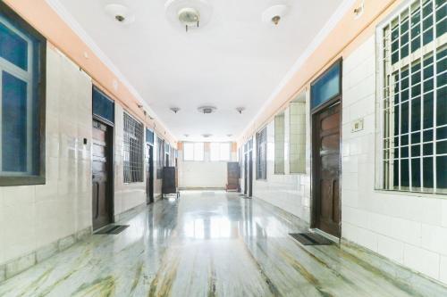 阿里格尔SPOT ON Hotel Anand Bhawan的一座白色墙壁和木地板的建筑的空走廊