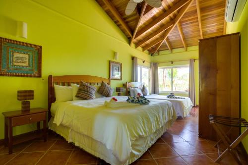 珀拉什奇亚Laru Beya All Inclusive Resort的一间设有两张床的卧室,位于拥有黄色墙壁的房间