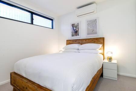 巴特曼斯贝Magnificent 1-Bed with BBQ and Views的白色的卧室设有一张大床和一个窗户