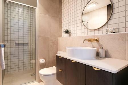 巴特曼斯贝Elegant Bay Side 1-Bed Apartment with Views的一间带水槽、镜子和卫生间的浴室