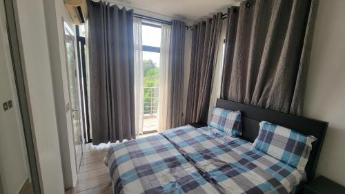 阿克拉Acasia Luxury Home Cantonment的一间卧室设有一张床和一个大窗户