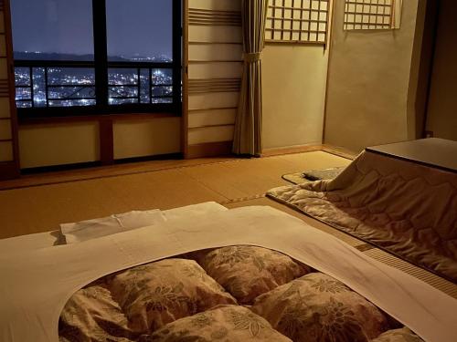 生驹Kanko Ryokan Yamato的窗户客房内的一张大床