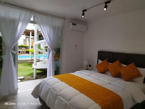 洛佩斯港Centro Vacacional "El Pro"的一间卧室配有一张床,享有游泳池的景色