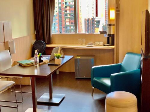 麦德林麦德林宜必思酒店的客房设有桌子、沙发、桌子和椅子。