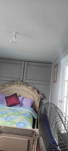 FolahaAJ Guesthouse的一间卧室配有一张带紫色和紫色枕头的床