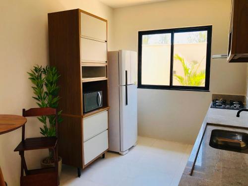 卡波布里奥Casa com piscina exclusiva的厨房配有冰箱和窗户。