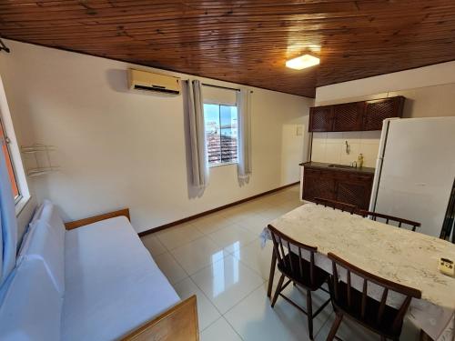 里约达欧特拉斯Pousada Bartrô的厨房配有桌椅和冰箱。