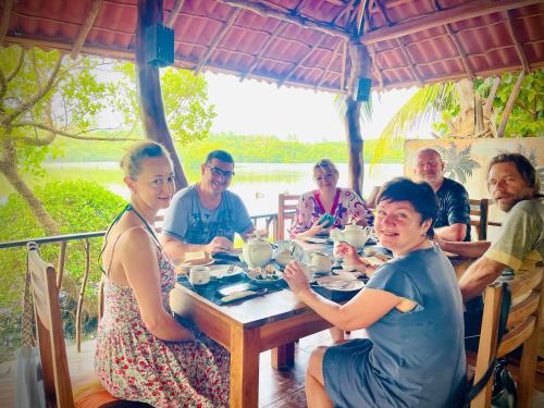 坦加拉鹰巢小屋酒店的一群坐在餐桌旁吃饭的人
