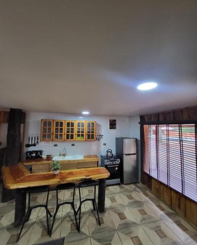 普孔Cabañas Condominio El Bosque的厨房配有木桌和冰箱。