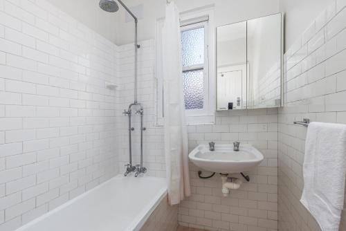 悉尼Luxe-Coastal Balmoral Beachfront Apartment的白色的浴室设有水槽和浴缸。