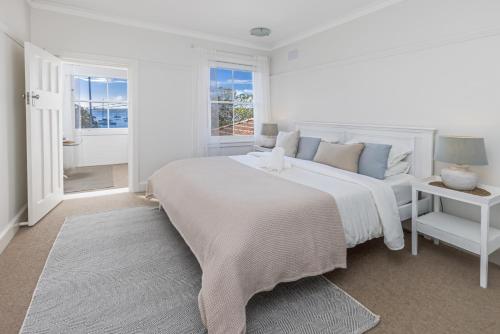 悉尼Luxe-Coastal Balmoral Beachfront Apartment的白色的卧室设有一张大床和一个窗户