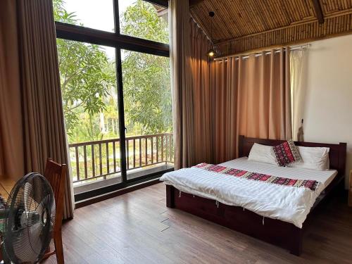 巴位Thang Mây Village Resort的一间卧室设有一张床和一个大窗户