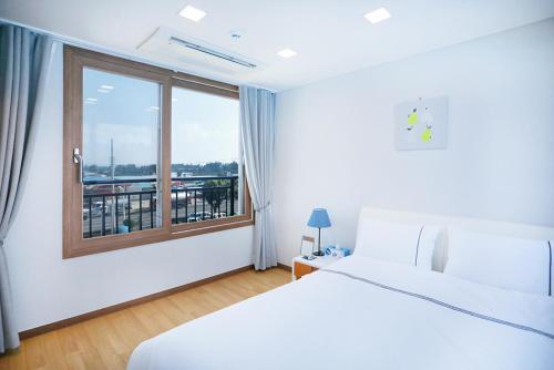 西归浦市The Naeun Stay的酒店客房设有床和窗户。