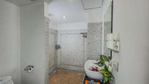 暹粒Dusit Hotel Siem Reap的白色的浴室设有水槽和淋浴。